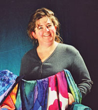 Photo of artist Artist holding several colorful pieces of fabric.